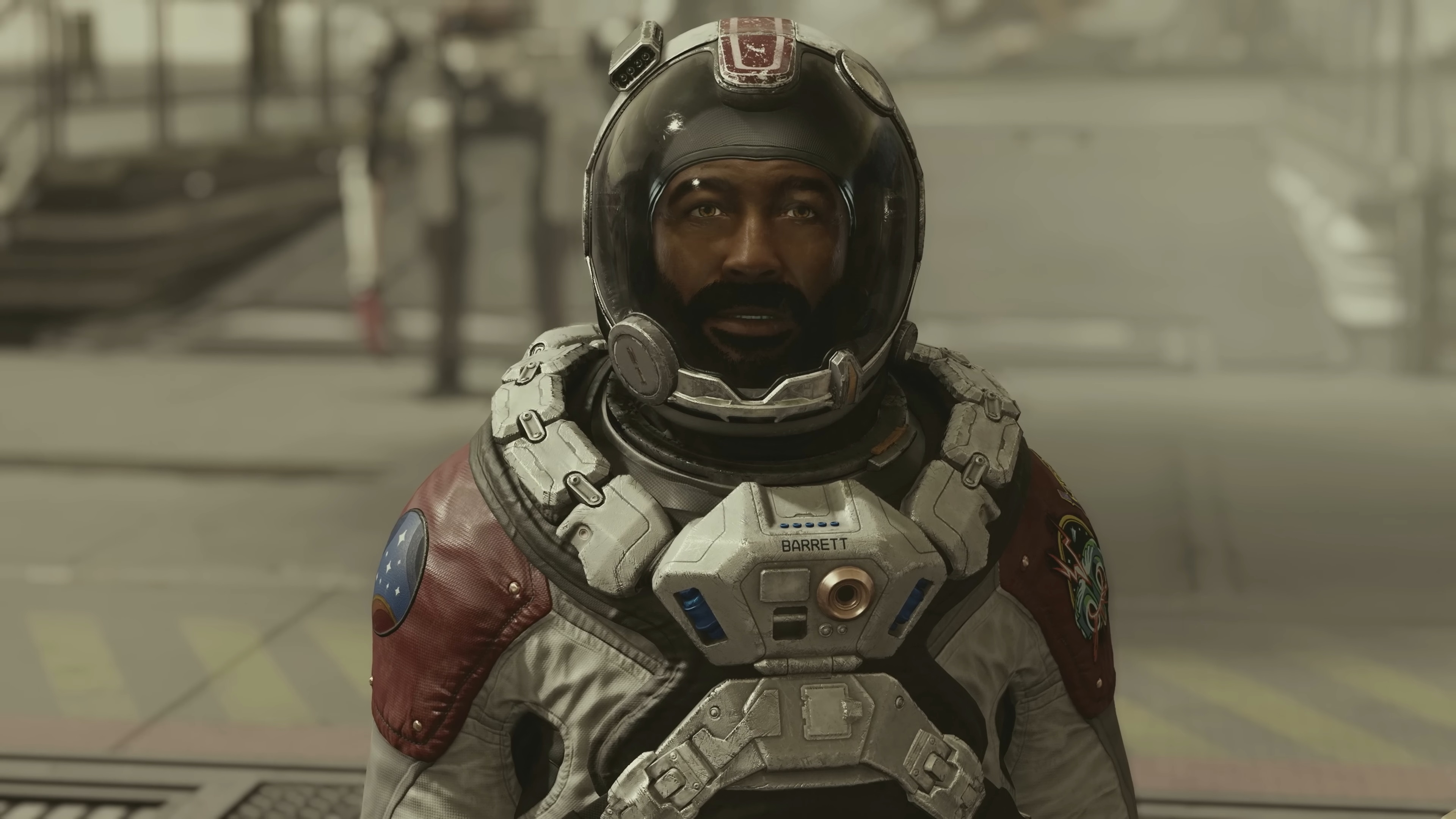 Starfield - Barrett uzay giysisi ve kaskıyla bir geminin dışında oyuncuyla konuşuyor