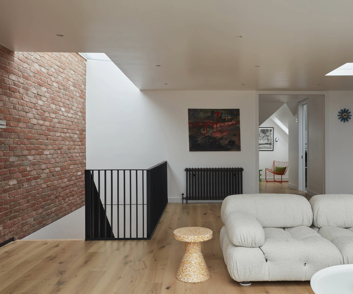 Loft conversion space with brick wall to the left hand side on the staircase