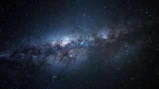 a bright white-blue smudge of gas in a starry night sky