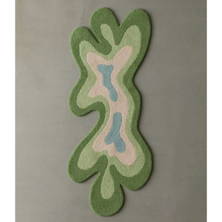 tufted rug in a splat shape with layers of green blue and cream