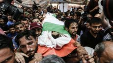 Mourners carry the body of 16-year-old Palestinian Louai Kaheel, who was killed by Israeli airstrikes over the weekend