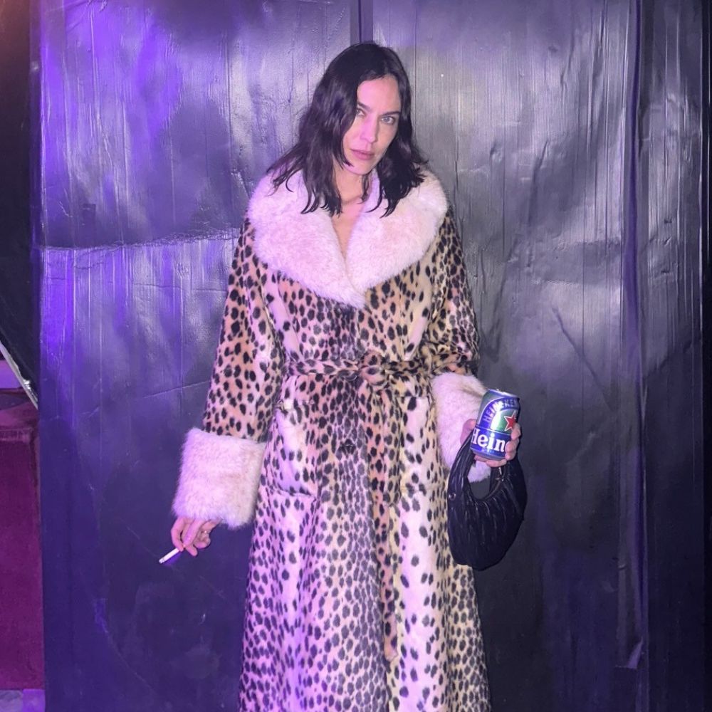 Alexa Chung wears the Queens of Archive Leopard print fur trimmed coat with red high heels and semi sheer tights.