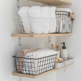 toilet paper storage in a floating shelf in a bathroom with white walls