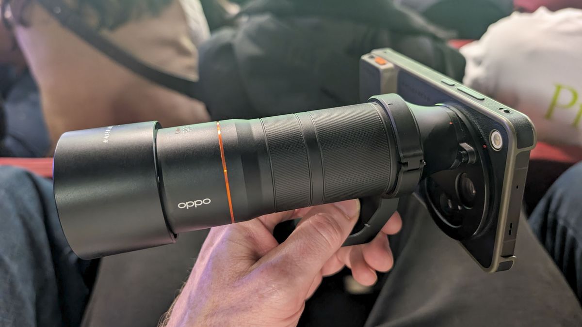 Oppo Find X9 Ultra with teleconverter lens attached, in the hand of user in the crowd at a soccer match