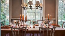 dining table laid with orange candles and flowers
