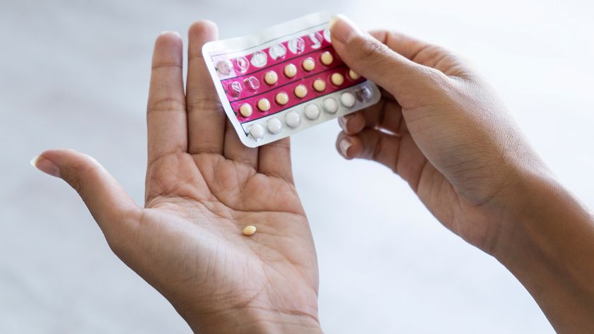 Close-up of young woman&#039;s hand holding birth control pills.