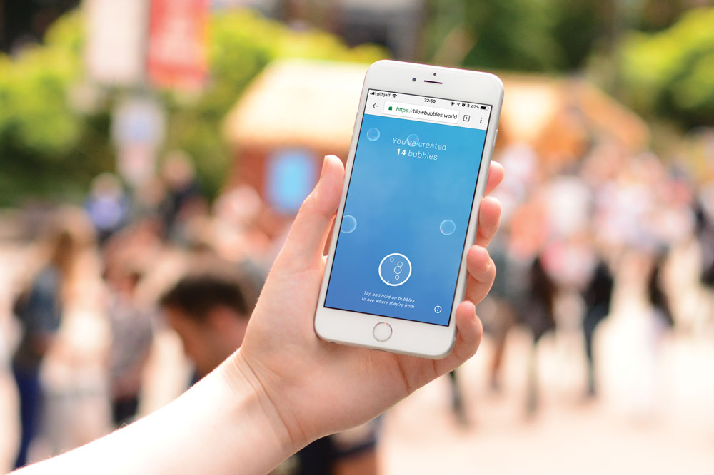 Hand holding a phone displaying Bubbles