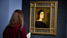 A woman in Rome looks at a self-portrait by Raphael