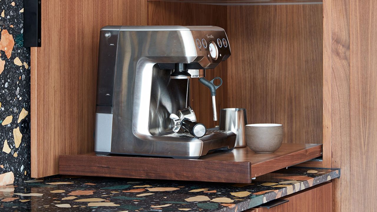 coffee niche with wooden cabinetry, terrazzo countertops, and a chrome coffee machine