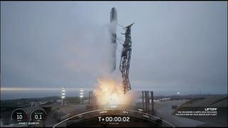 a rocket lifting off above a plume of fire. gray clouds are in the background