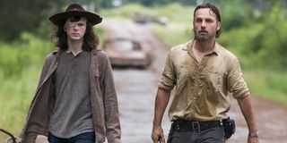 The Walking Dead Carl Grimes and Rick Grimes walking down road AMC
