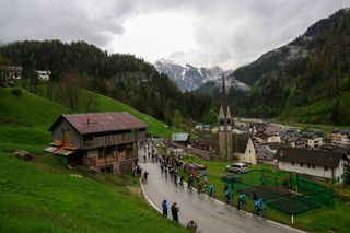 Cyclists ride through the village of Caprile during the 16th stage of the Giro dItalia 2021 cycling race 153km between Sacile and Cortina dAmpezzo on May 24 2021 Photo by Luca Bettini AFP Photo by LUCA BETTINIAFP via Getty Images