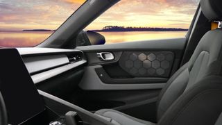 Warwick Acoustics Electroacoustic speakers in an EV, seen in the door of the car, parked to watch a sunset