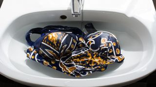 A swimsuit in a sink being handwashed