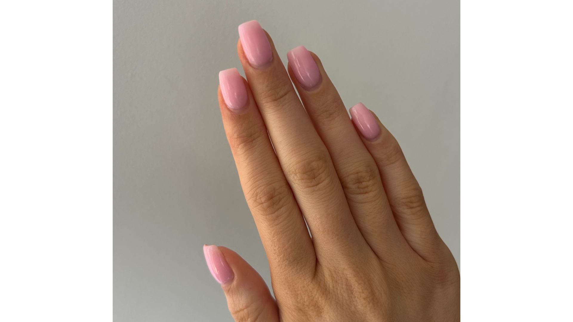 A close-up of Digital Beauty Writer, Sennen Prickett's hand with square, candy-floss pink nails