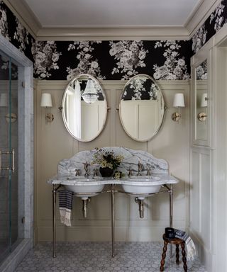 Bathroom with a veined marble vanity unit, marble floor tiles, floral wallpaper and painted paneling