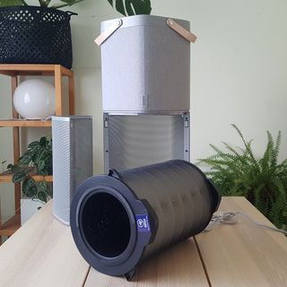 The AEG AX91-604GY Connected Air Purifier being tested in a room with green walls and a wooden table