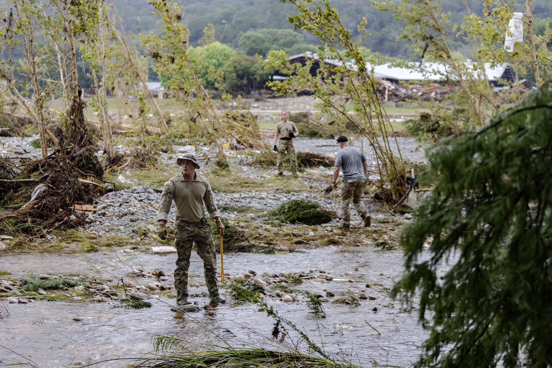 Search and rescue workers look through debris for survivors after a flood