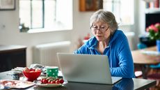 Older woman at table looking at computer
