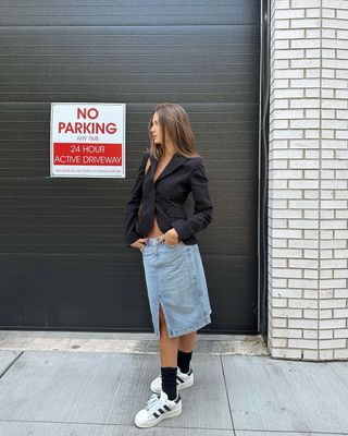 woman wearing white sneakers with denim midi skirt spring outfit