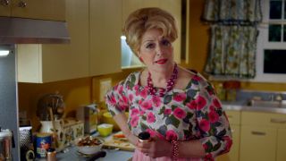 Caroline Aaron as Shirley Maisel standing in the kitchen