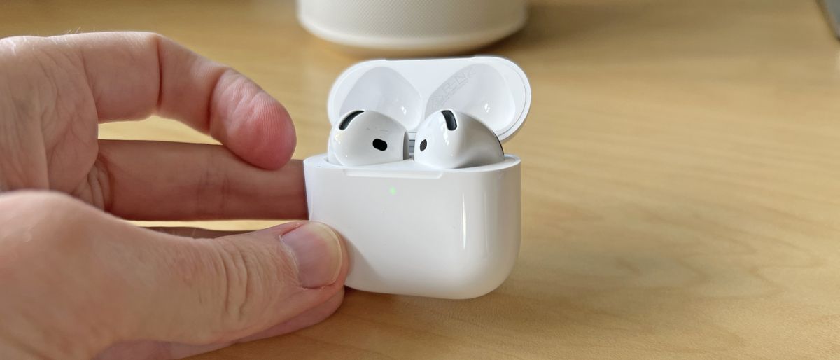 AirPods 4 with ANC in their case, held in a man&#039;s hand