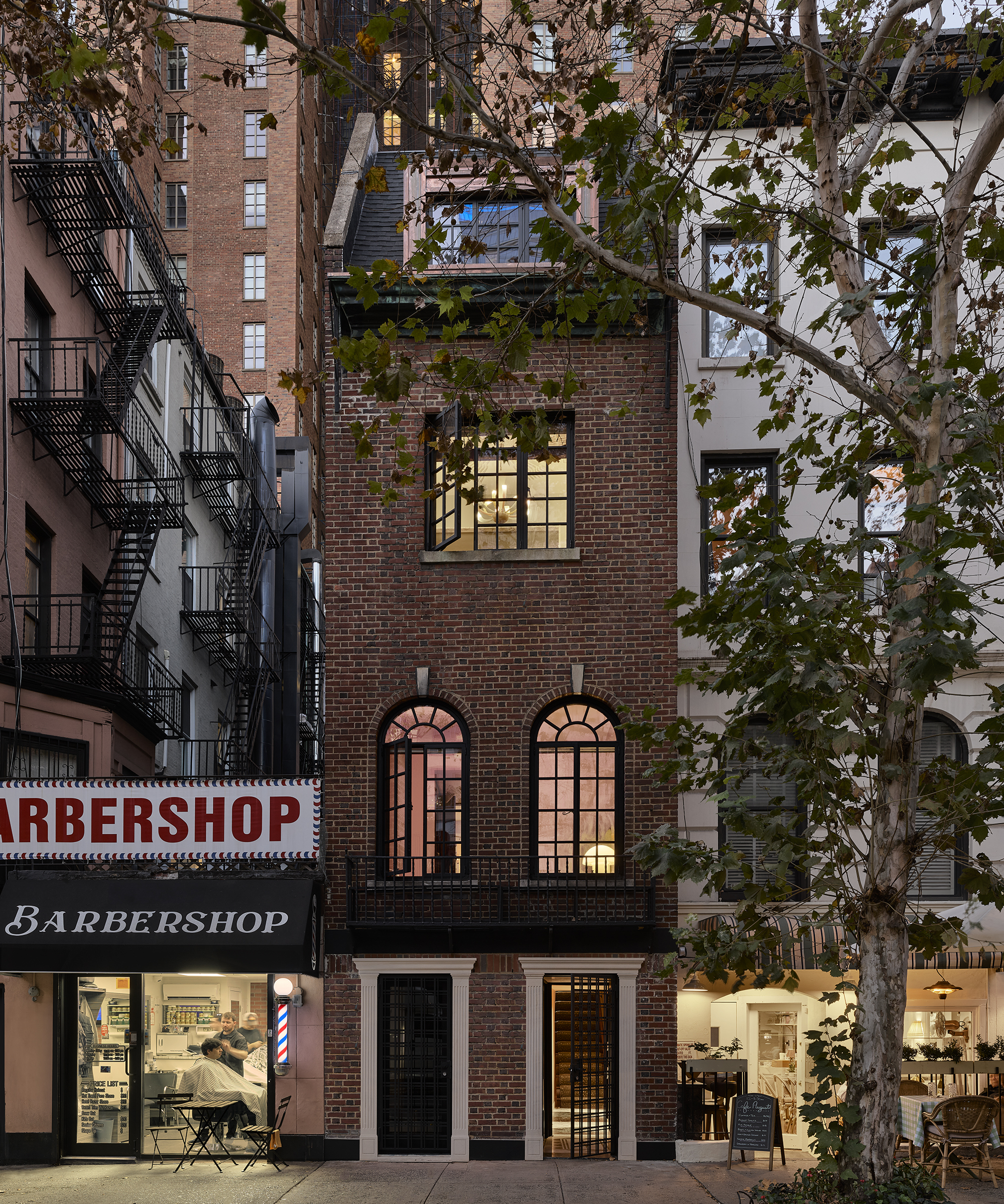 exterior of a new york townhouse next to a barbershop