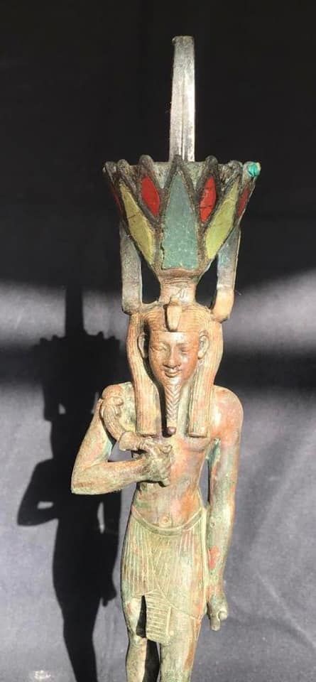 This bronze statue of the god Nefertem was found near the coffins. It has a lotus-shaped headdress made of red agate stone, turquoise and lapis lazuli.