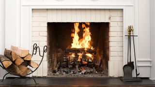 Cream brick open fireplace with fire and large slate hearth