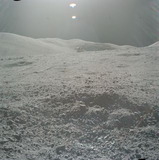 The crater containing sample 70019, with the Apollo 17 lunar module in the background.