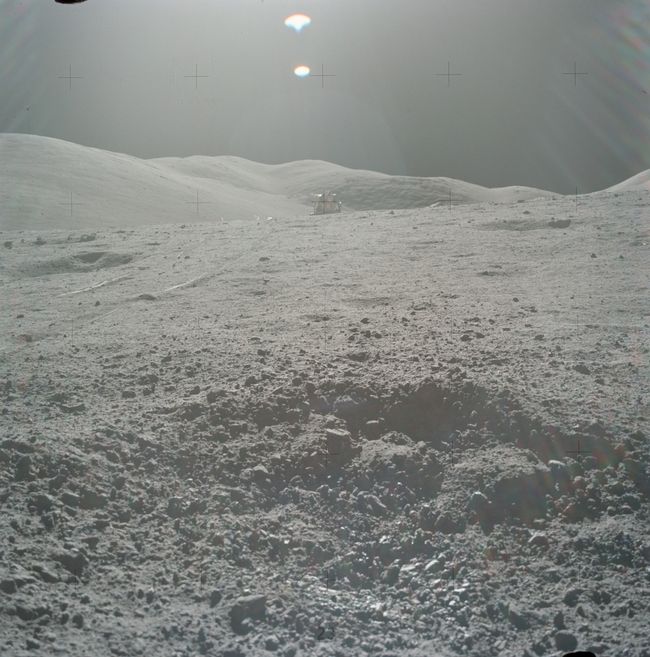 The crater containing sample 70019, with the Apollo 17 lunar module in the background.