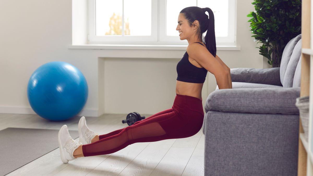 Woman does triceps dips off sofa