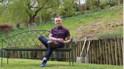 Garden Rescue&#039;s Lee Burkhill poses in a verdant green outdoor setting