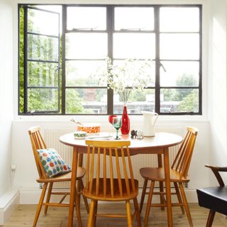 original crittall windows in 20th century london home wooden table and chairs in front of window