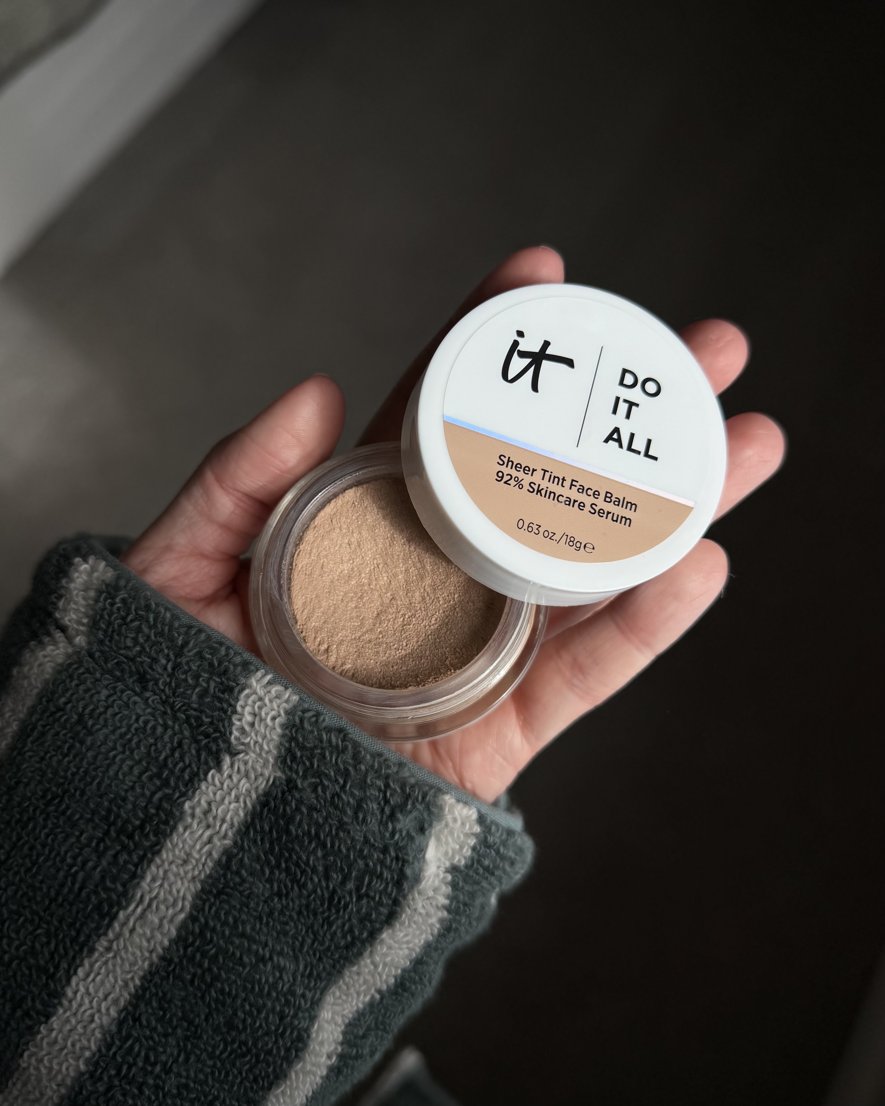 An image ofBest Knockoff Luxury Clothing
 associate beauty editor Alyssa Brascia holding the It Cosmetics Do It All Sheer Tint Face Balm.