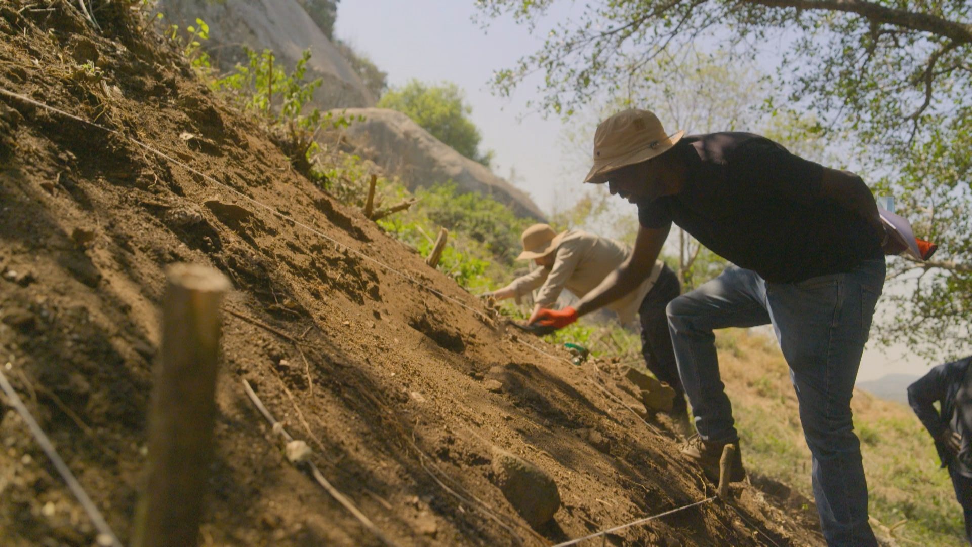 a man excavates a steep hillside