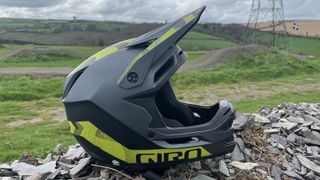 Giro Insurgent Spherical full-face helmet sitting on a wall with countryside backdrop