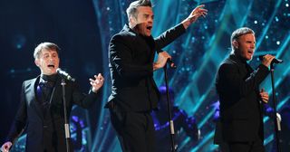 Mark Owen, Robbie Williams and Gary Barlow of Take That on stage during the 2011 National Movie Awards at Wembley Arena, London