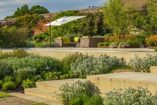 Vines and passionfruit are trained against the south-west-facing weathered brick wall that remains from the old walled garden. Photography by Clive Nichols.