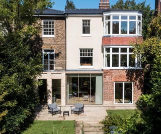 large property with a variety of different finishes on the exterior, including red brick and a lighter brick extension