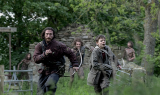 A man and a young boy run from a hoarde of zombies