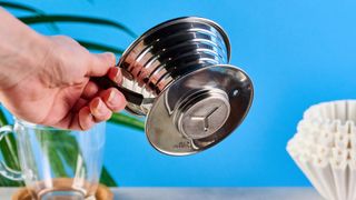 kalita wave stainless steel pour-over coffee dripper photographed against a blue background with kalita filters