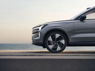 Front side view of Volvo EX90 beside expanse of water