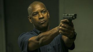 Denzel Washington holding gun as Robert McCall in The Equalizer