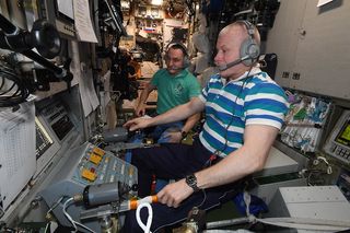 Cosmonauts Pyotr Dubrov and Oleg Novitsky monitor the arrival of the Nauka module from inside the International Space Station on July 29, 2021.