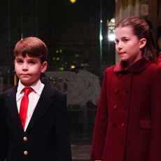 Prince George and Prince Louis wear matching suits with white shirt and red ties, while Princess Charlotte wears a red coat to attend Kate Middleton's Christmas carol concert