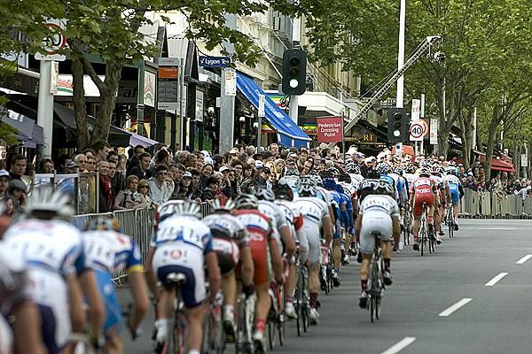 The peloton head up Lygon Street before thousands of fans.