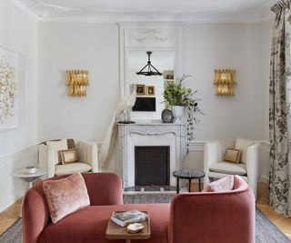 living room with pink tete at tete sofa and two white armchairs near fireplace