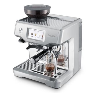 A Breville Barista Touch coffee machine making coffee on a white background