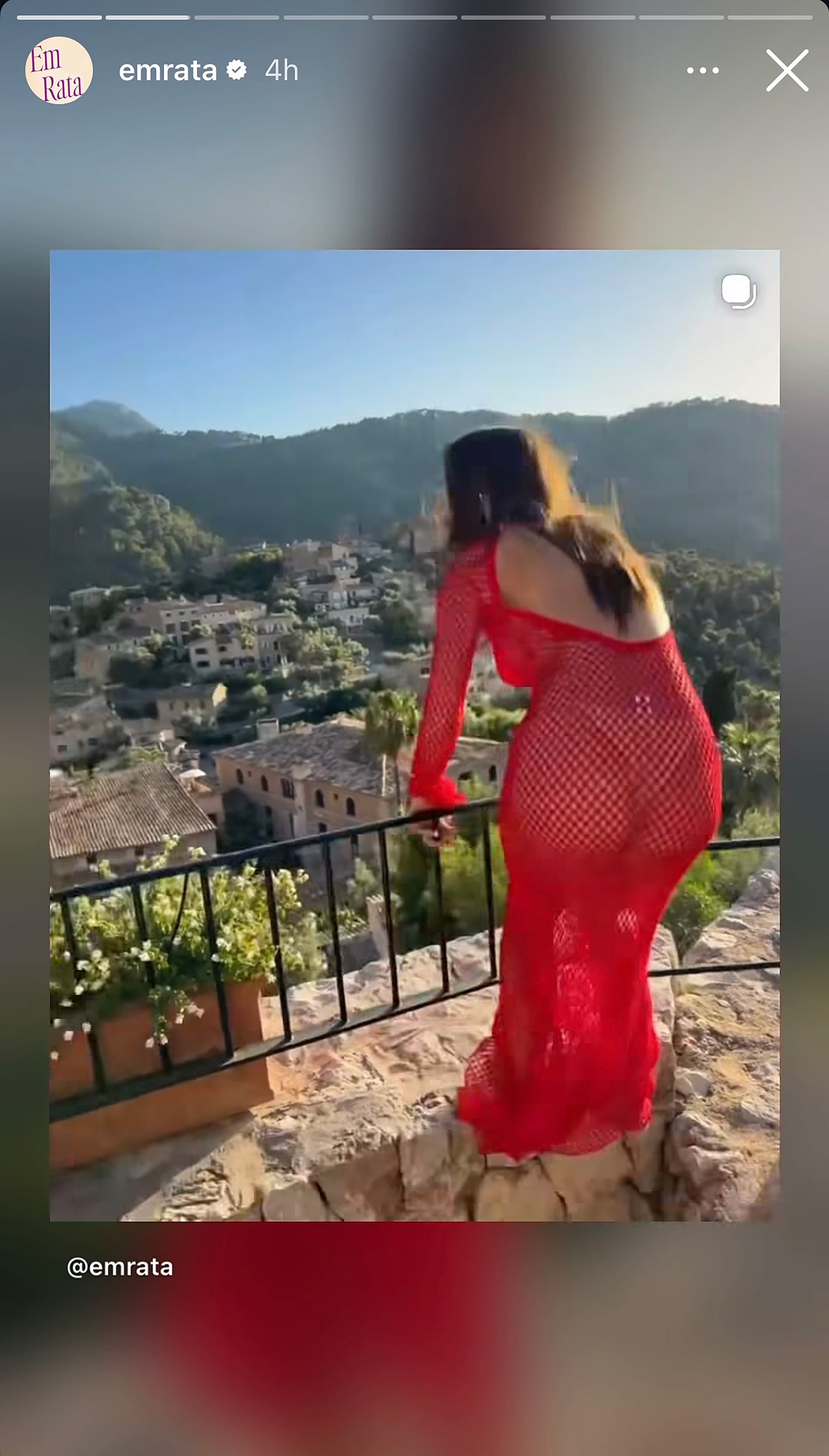 Emily Ratajkowski trips in screenshot from video. while taking pics of netted red gown on vacation in Mallorca.